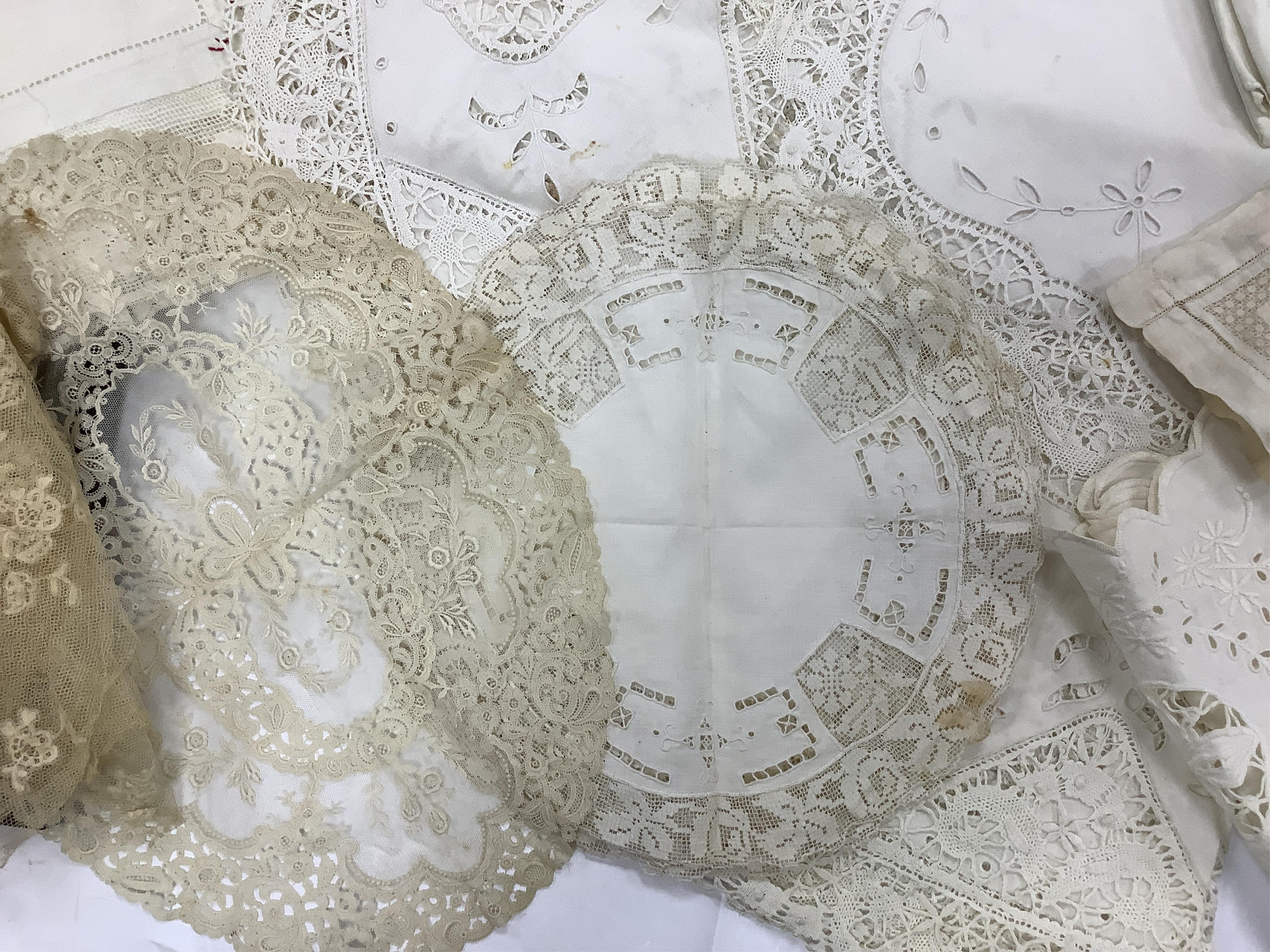 A small box/trunk containing mixed crochet, embroidered anglaise and drawn thread table linens, christening gown, damask cloths and various pieces of lace etc.Ornate circular cloth 112cm diameter. Condition - most need r